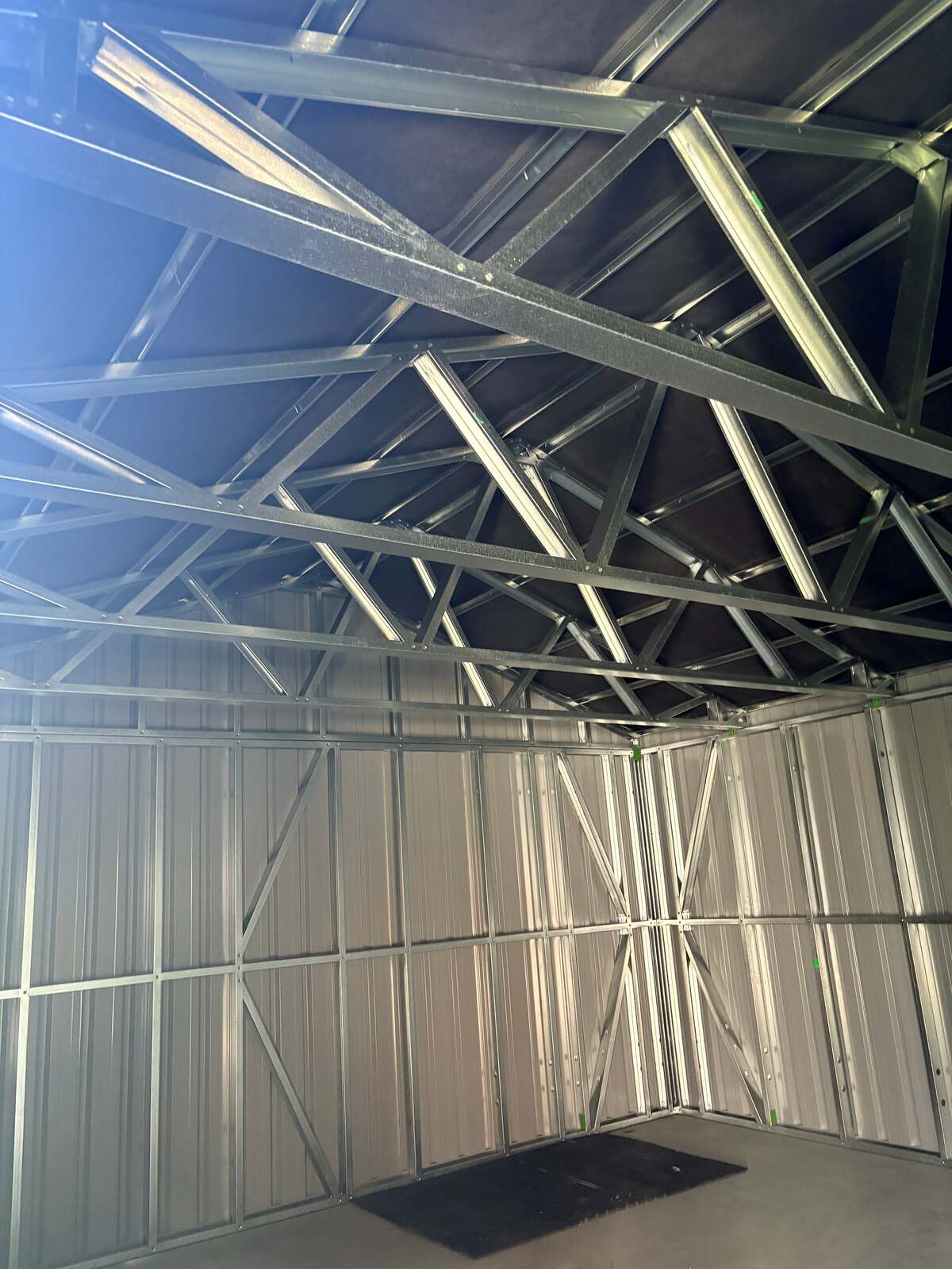 Inside the garage looking up at the steel frames and trusses